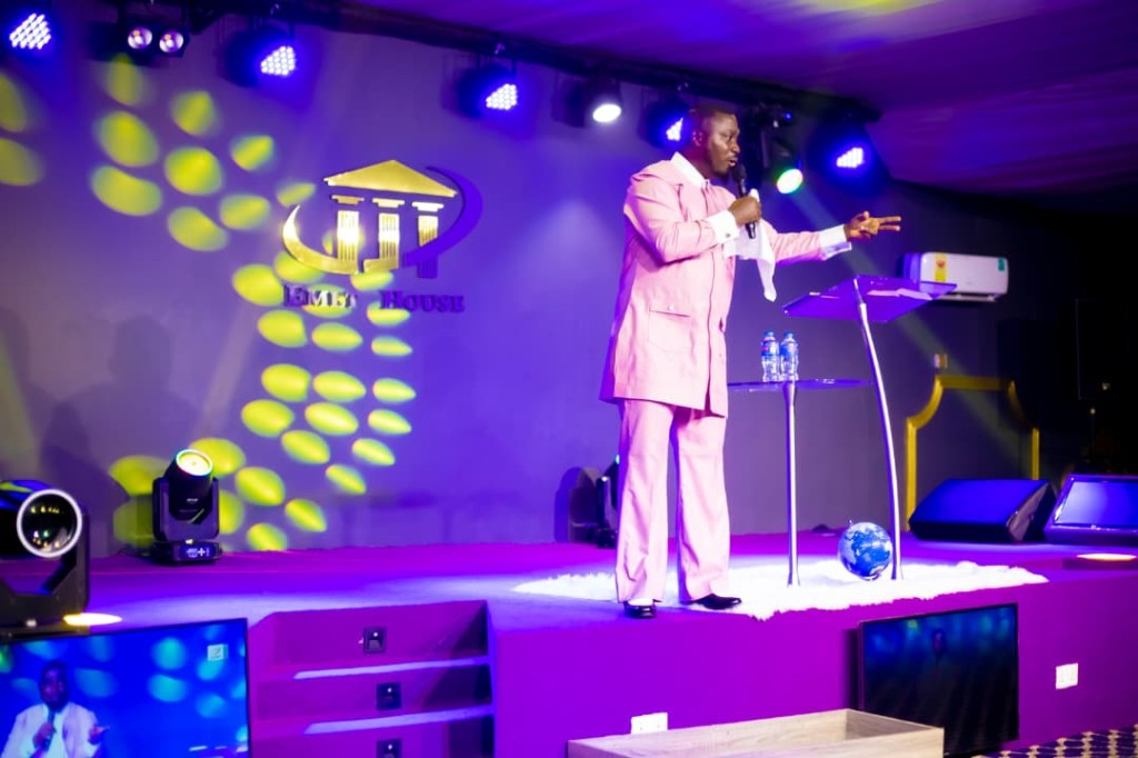 Bishop preaching on stage with EMET House Chapel backdrop